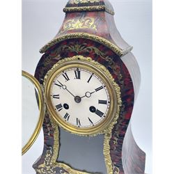 19th century brass inlaid red Boulle work mantel clock on ornate gilt stand, cartouche shaped case with floral urn finial, circular white enamel Roman dial above window, mask cast pendulum, ornate foliate moulded slip, twin train eight day movement striking on bell by Japy Freres, the gilt serpentine stand with scroll shell cartouches 