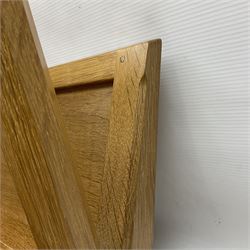 Mouseman - oak magazine rack, the top rail pierced with handle and carved with mouse signature, octagonal supports with two panelled and splayed sides, on sledge feet, by the workshop of Robert Thompson, Kilburn 