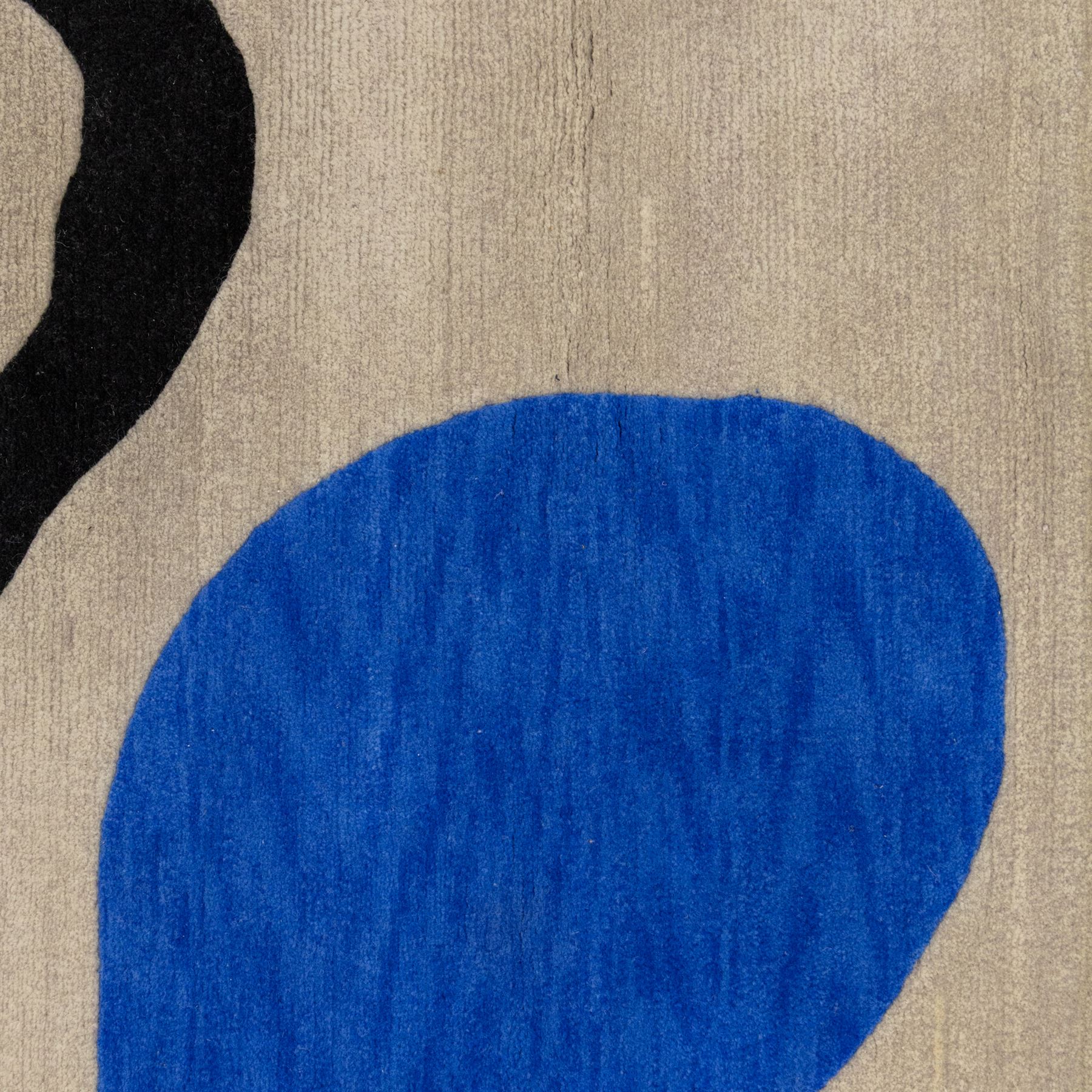 Rugs by Design - ‘Soft Landing’ Nepalese thick pile wool rug, with contemporary abstract design on a taupe ground, decorated with rounded blue forms and a bold black irregular loop motif