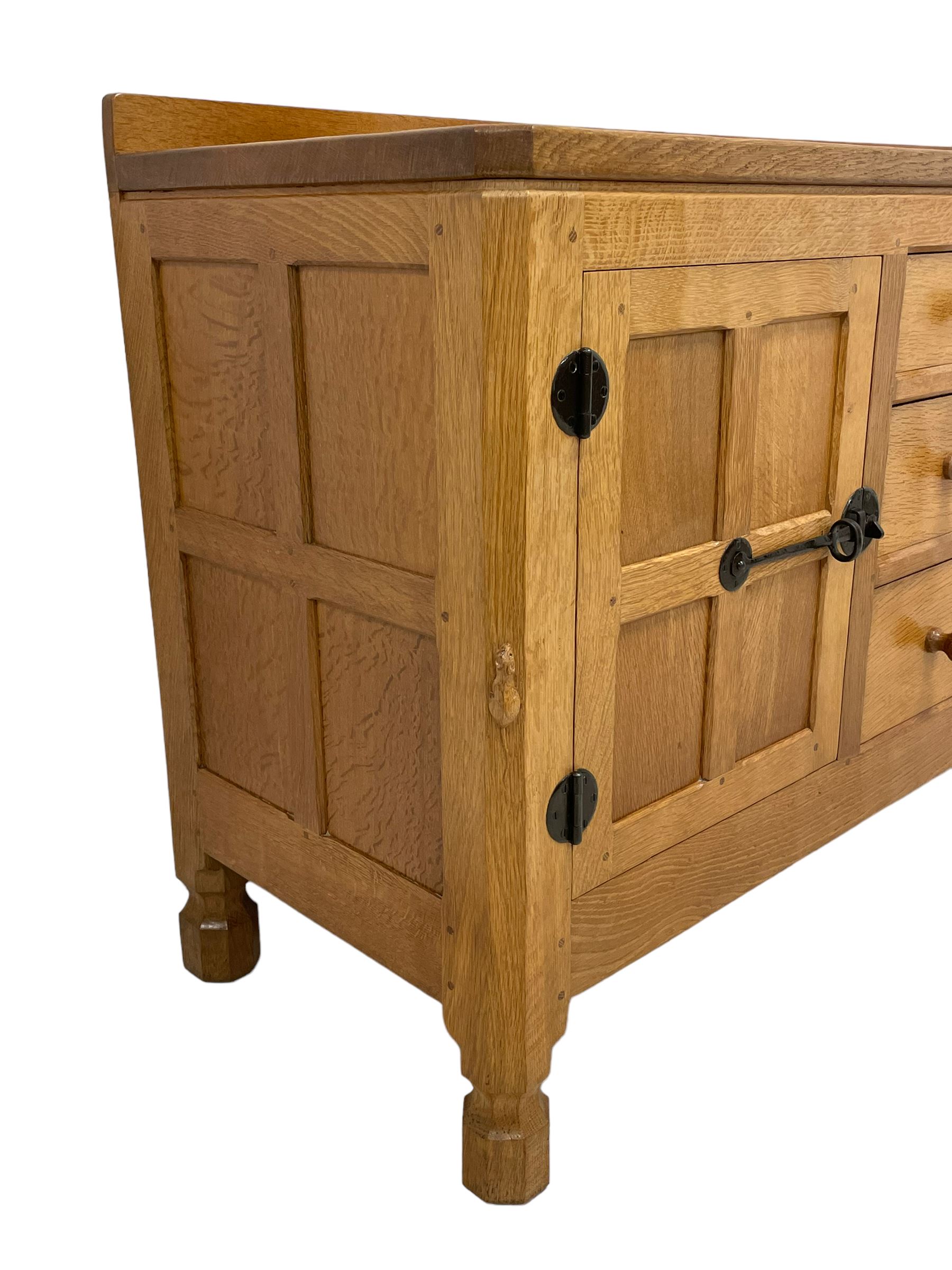 Mouseman - oak dresser, rectangular adzed top with raised back over three central drawers and two flanking cupboards, enclosed by panelled doors with wrought metal fixtures, the canted upright carved with mouse signature, on octagonal feet, by the workshop of Robert Thompson, Kilburn