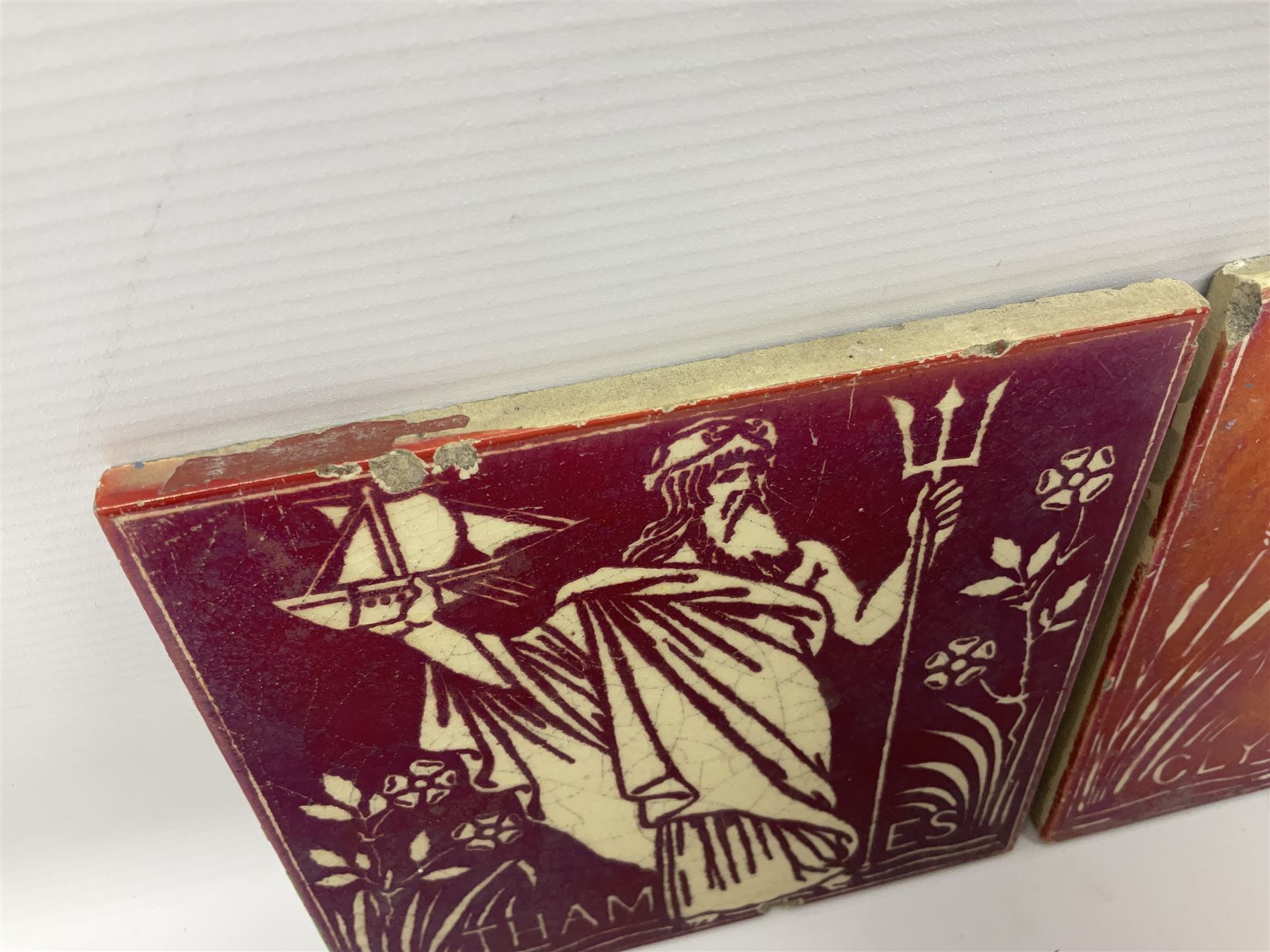 Pair of Maw & Co Benthall Works tiles, each depicting classical figures with fishing and shipping details, one inscribed Thames, the other Clyde, upon a red lustre ground, with raised marks verso, H15.2cm