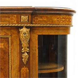 Large fine Victorian figured and burr walnut credenza, the breakfront D-shaped top with moulded edge, over an ornate frieze with inlaid Aesthetic Movement scrolling and geometric ornament, applied with gilt-metal ribbon-twist moulding and mounts, the central panelled doors profusely inlaid with scrolling foliate motifs and stringing, flanked by gilt-metal cartouche and scrolling acanthus corbel mounts, with flanking glazed bow-front side doors, on skirted base with further gilt metal foliate mounts