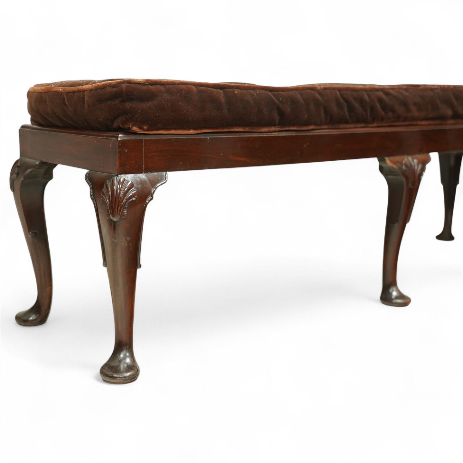 Early 20th century mahogany window seat in the George II style, with rectangular padded seat upholstered in brown velvet, raised on cabriole legs with carved shell knees and pad feet