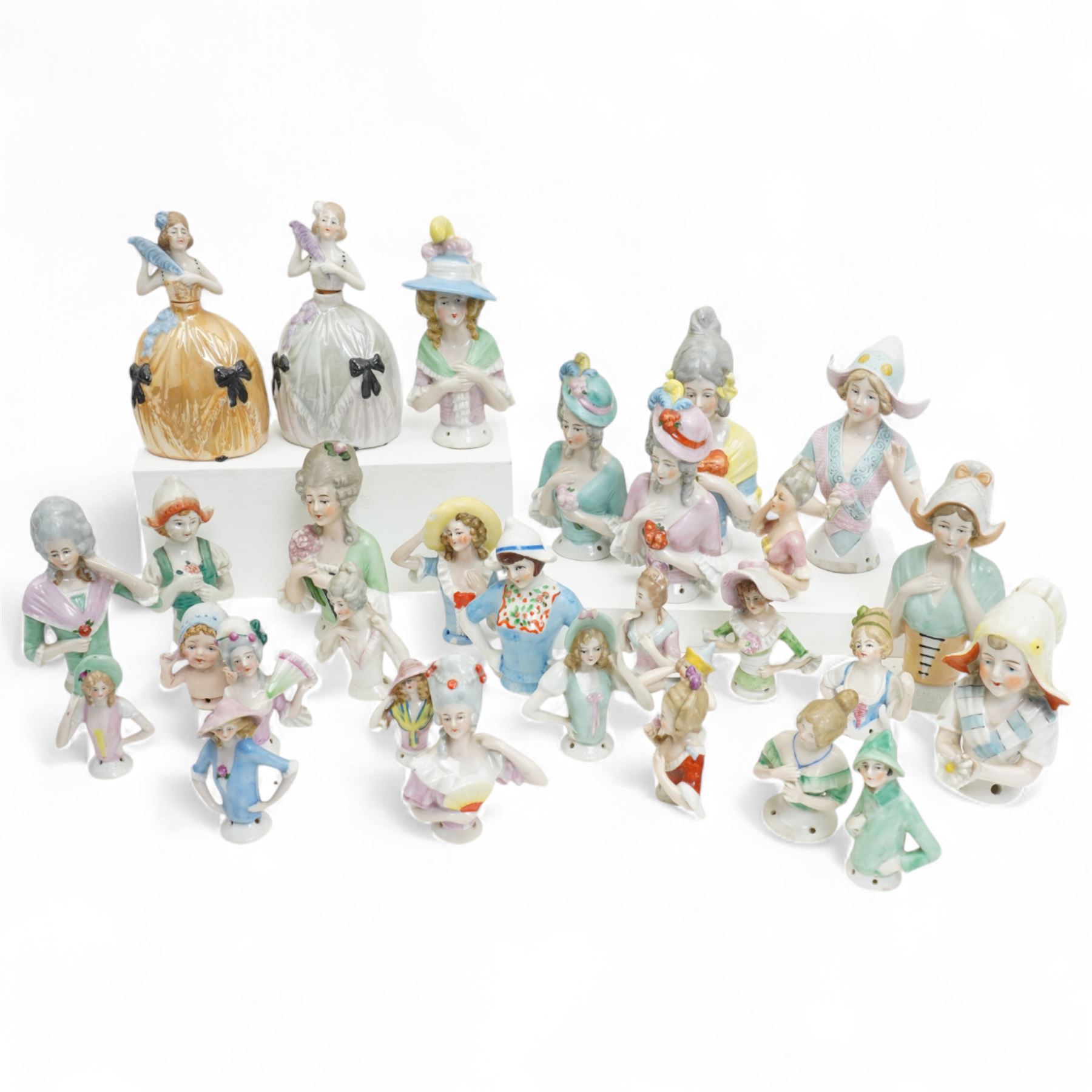 Collection of early 20th century ceramic half dolls, approximately 26, together with two novelty flasks in the form of ladies in evening dresses