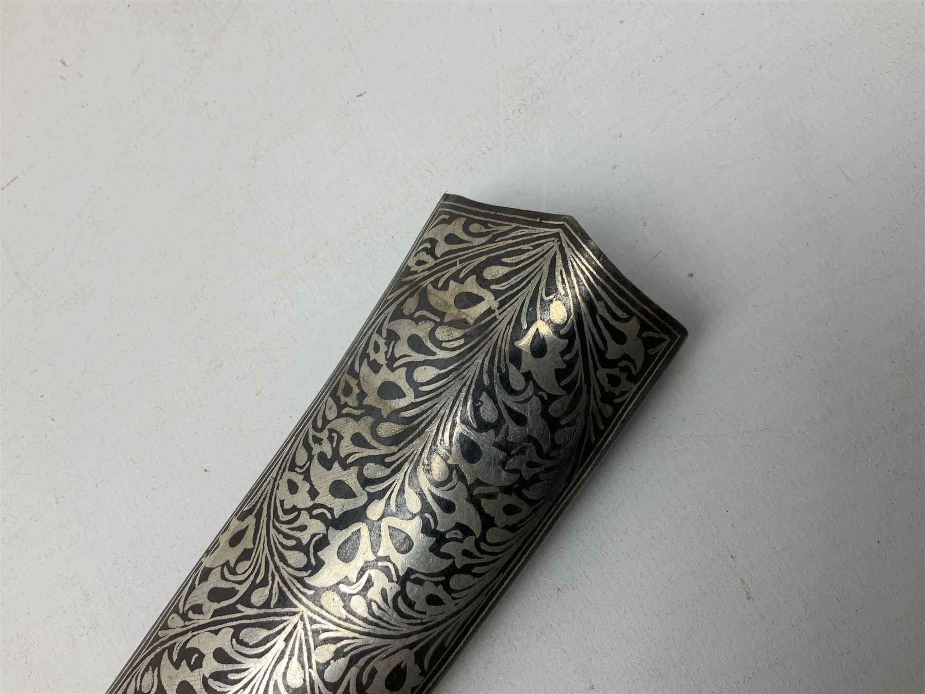 Indian Khanjar dagger with 28cm curving damascus steel blade inlaid with silver floral emblem, white metal and niello style grip in the form of a bird's head with pronounced beak and matching scabbard L44cm overall
