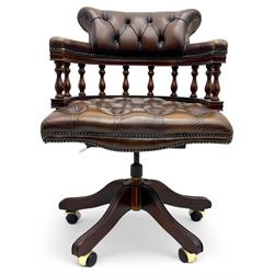 Mahogany framed swivel Captains desk chair, upholstered in brown buttoned leather, turned supports and swivel base on castors
