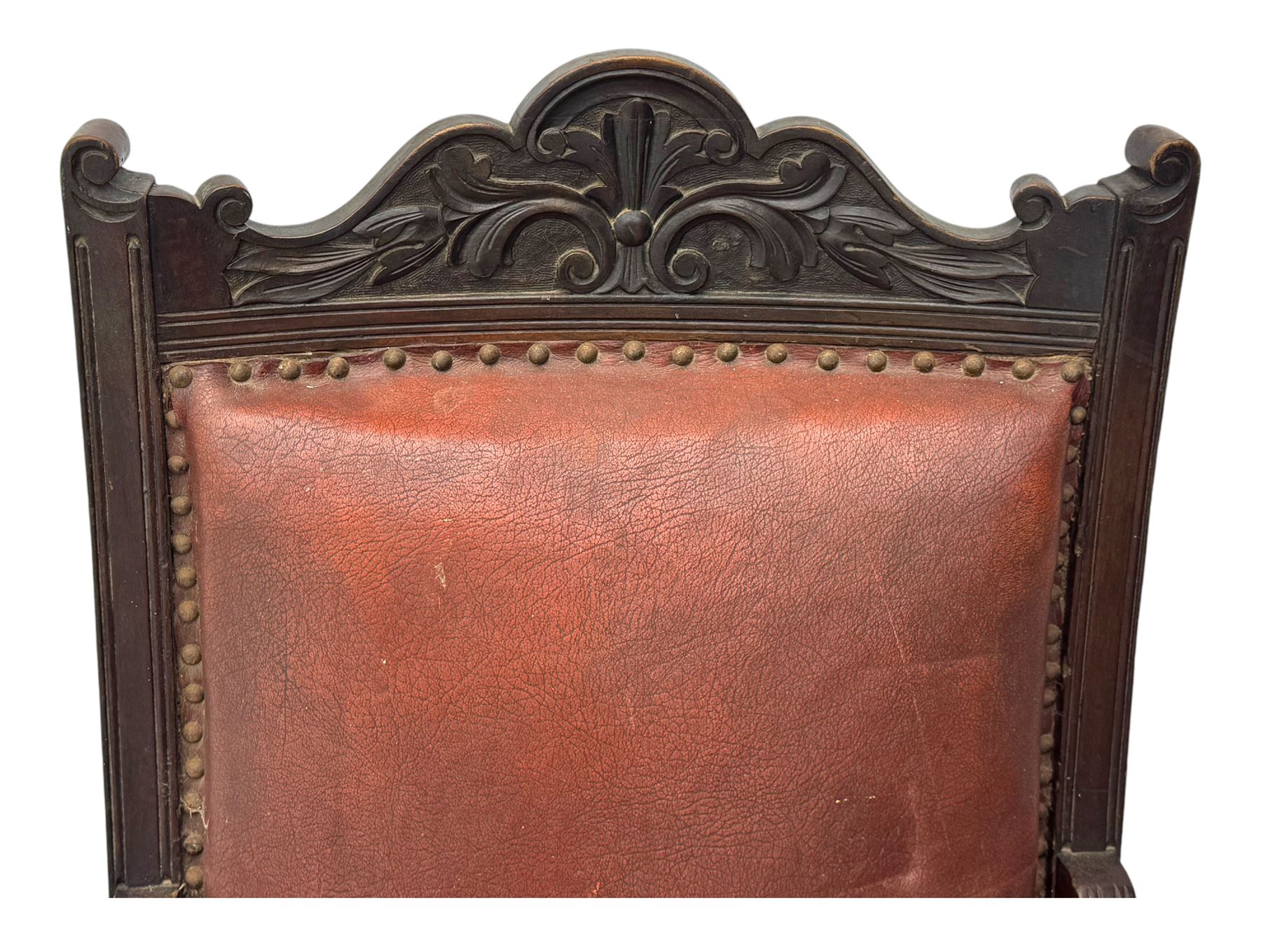 Victorian walnut framed armchair, shaped pediment carved with scrolling foliage, upholstered in leather, on ring turned front feet