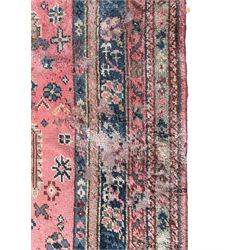 Large early 20th century Turkish red ground carpet, the field decorated with stylised plant motifs, multiple band border decorated with flower heads and repeating patterns 
