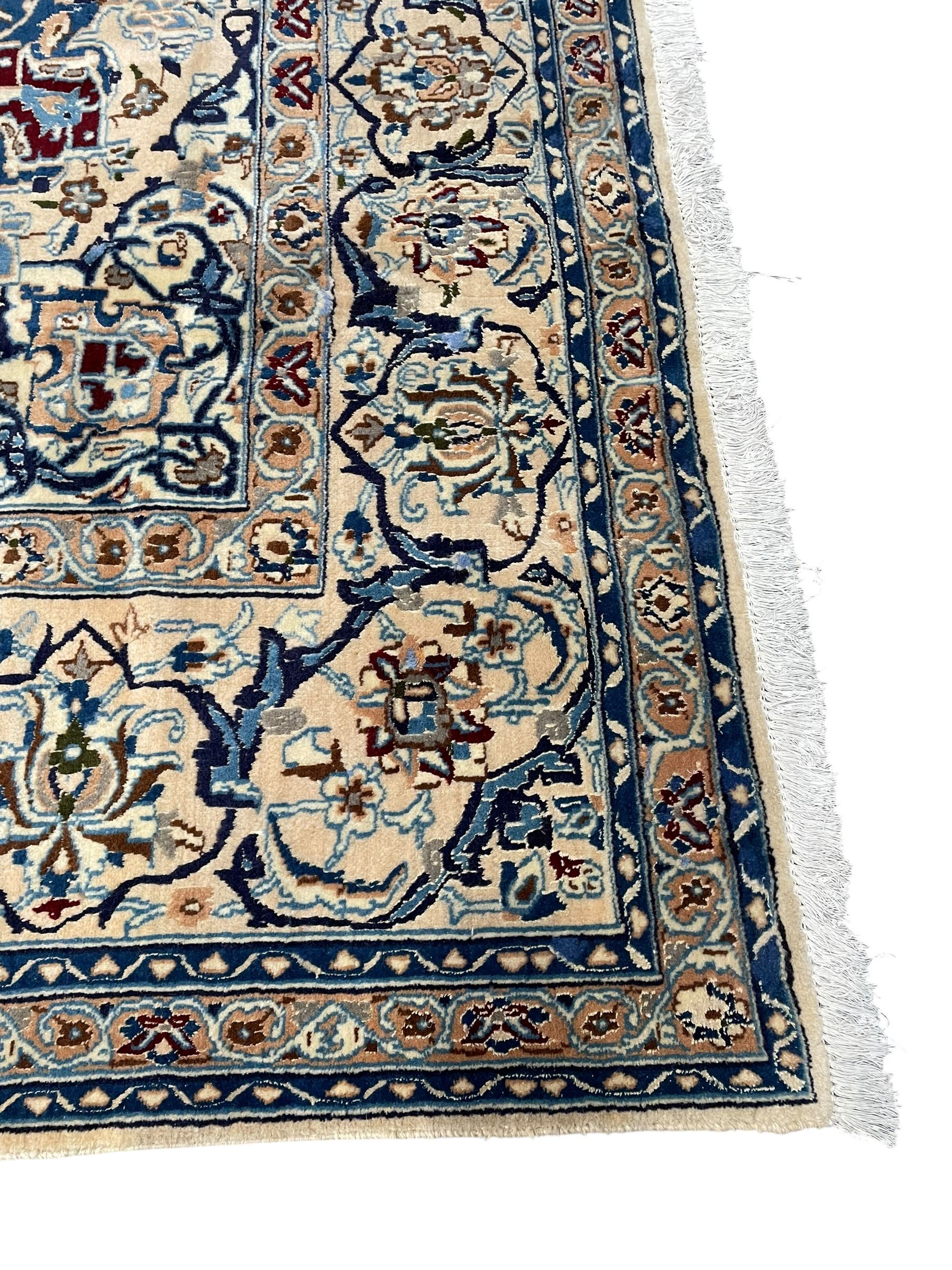 Persian Kashan blue ground rug, central floral rosette medallion within a field of swirling branches and palmettes, the border with trailing pattern interspersed with stylised plant motifs