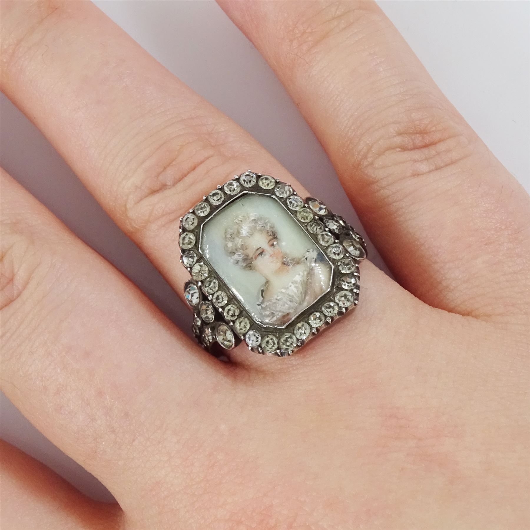 19th century 18ct gold and silver paste set portrait ring, octagonal miniature of a woman on ivory, under a glazed panel, with paste stone surround, to bifurcated paste set shoulders. This lot has been registered for sale under Section 10 of the APHA Ivory Act