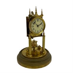 Gustav Becker 400-day torsion clock, serial No 2056379, with an adjustable rotary torsion pendulum and intact suspension, with a circular brass base and glass dome, cream enamel dial with roman numerals, minute markers and steel spade hands.

