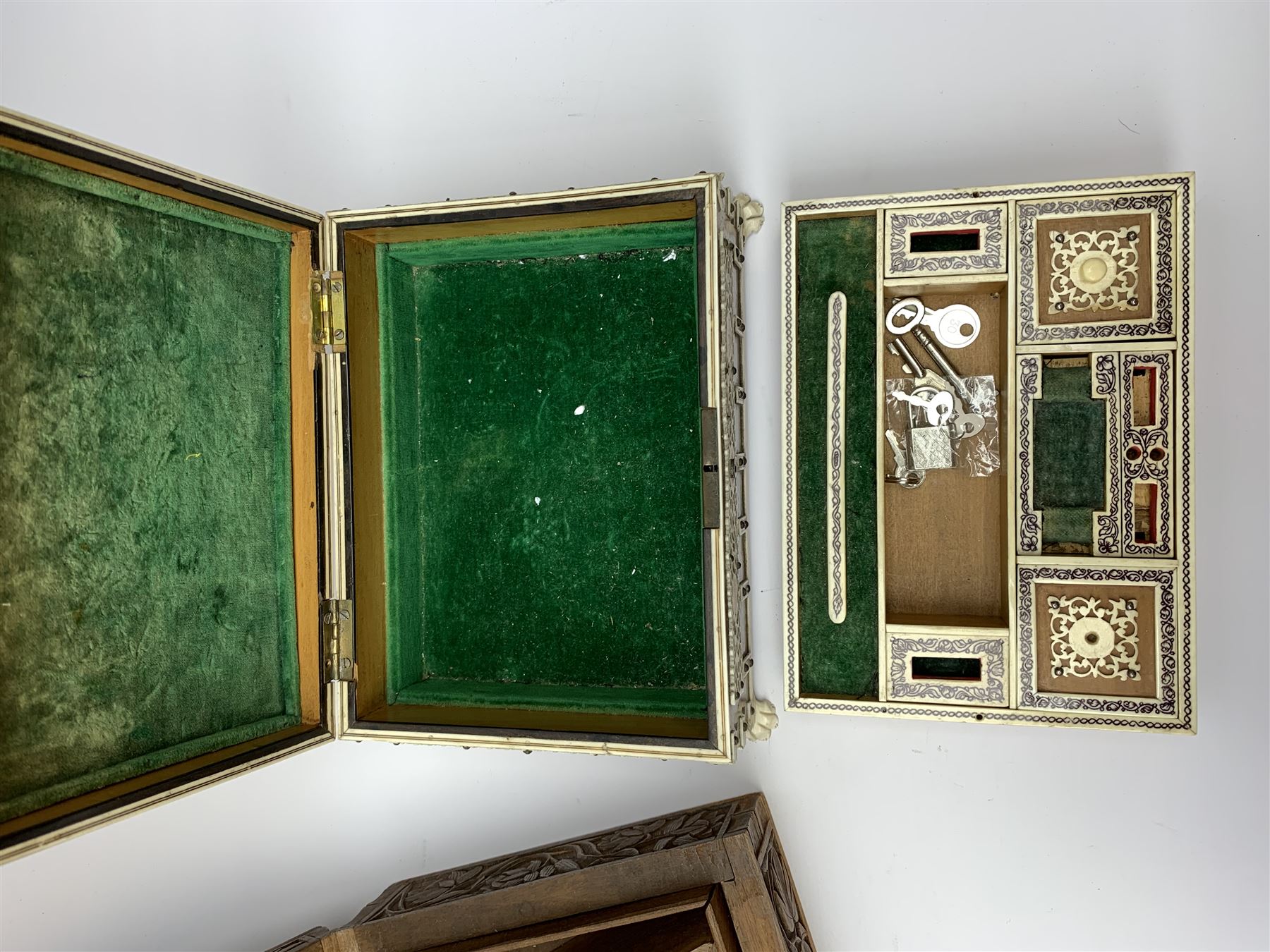 An early 20th century Indian Vizagapatam box, detailed with pierced ivory panels and raised upon four paw feet, H8cm L20.5cm D15.5cm, together with an Eastern hardwood box carved with foliate panels. 