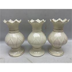 Five late 19th/early 20th century and later Belleek vases, comprising pair of Lotus Blossom examples, shamrock tree trunk vase, twin handled shamrock vase and a baluster form vase decorated with applied roses, all with printed marks beneath, tallest H16cm