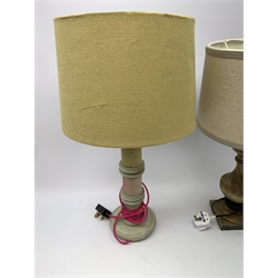 A turned wooden lamp base, with cream shade, overall H53cm, together with another wooden lamp base, the column modelled as three bobbins, with yellow shade and pink flex, overall H58cm. 