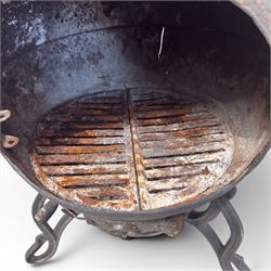 Cast iron garden chiminea, with mesh front spark guard, flue chimney on three splayed legs, finished in black.