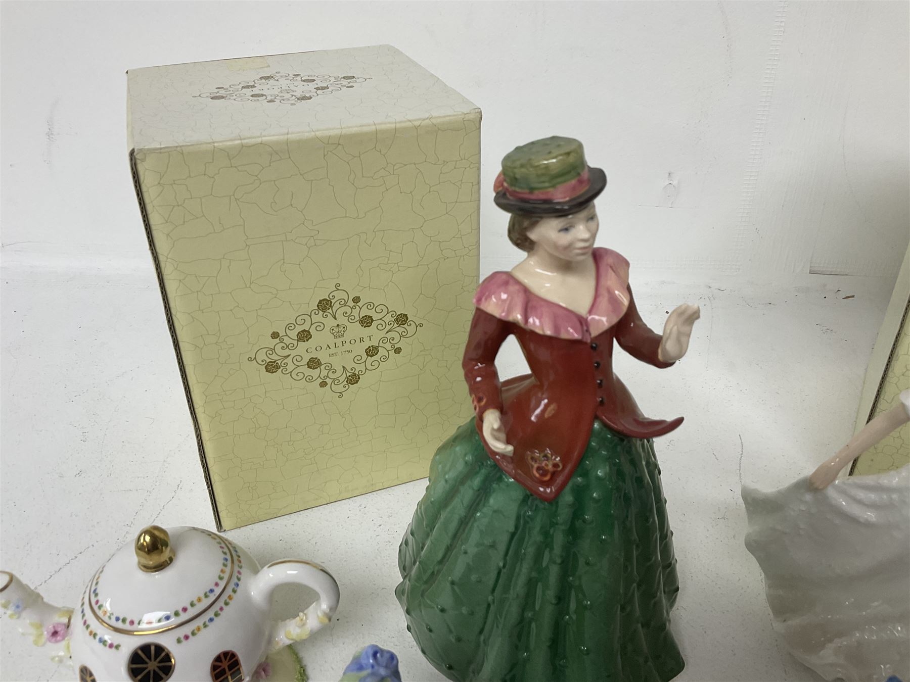 Two Coalport cottages, comprising Teapot cottage and Easter Cottage, together with four Royal Doulton figures, including Holly and Friendship 