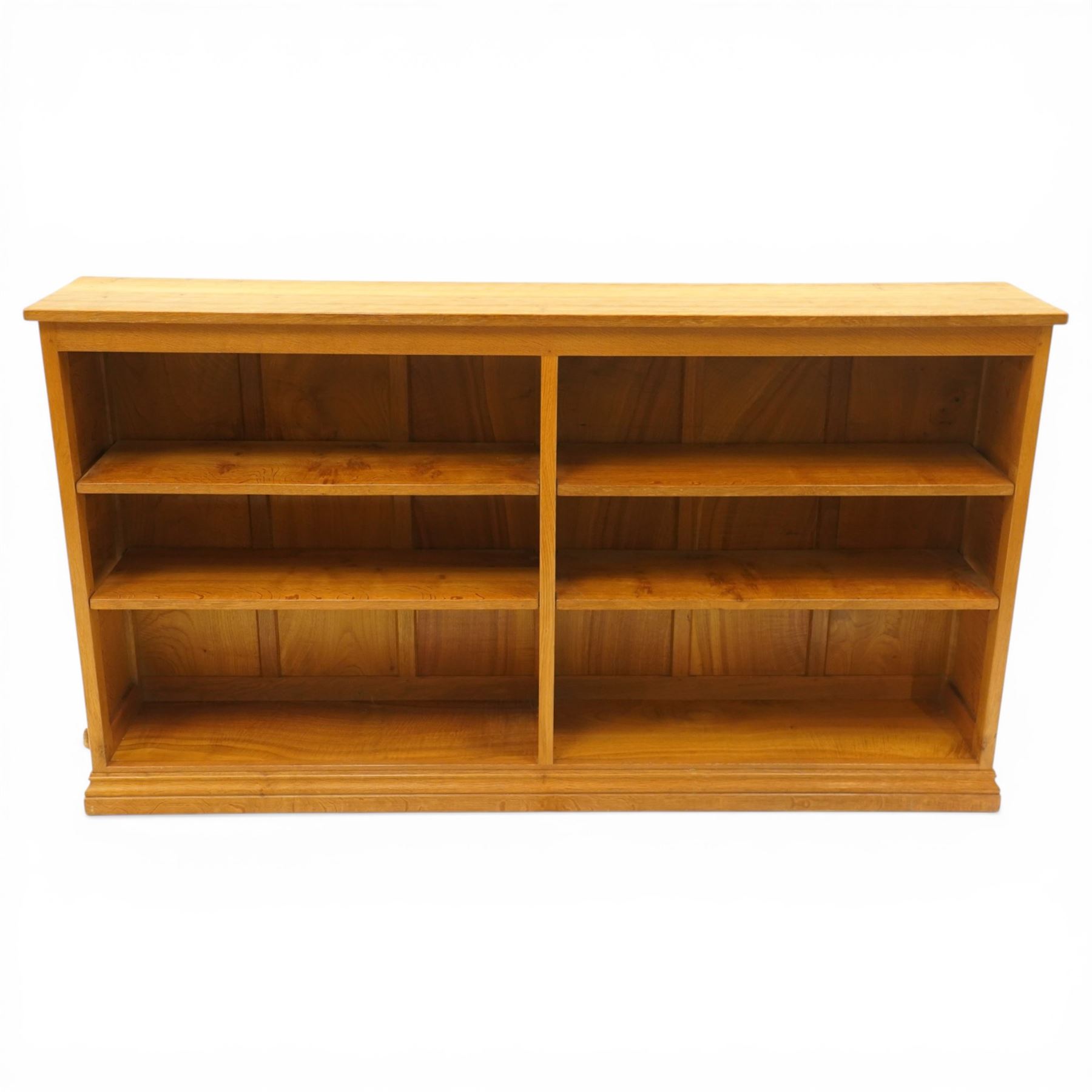 Beaverman -  Adzed oak open bookcase, with two sets of two adjustable shelves, panelled sides on a plinth base, with carved beaver signature, by Colin Almack of Sutton near Thirsk