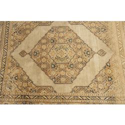 Two hand-knotted rugs, comprising Persian medallion rug and tribal rug, Persian hand-knotted rug, ivory ground centred by shaped floral medallion with pendants, surrounded by stylised flowerheads and foliate motifs, enclosed by multiple floral and geometric borders, H155cm, W123cm; tribal hand-knotted rug, dark brown ground with repeating linked geometric diamond medallions in orange and green, enclosed by ivory geometric border, striped ends with fringes, H150cm, W71cm