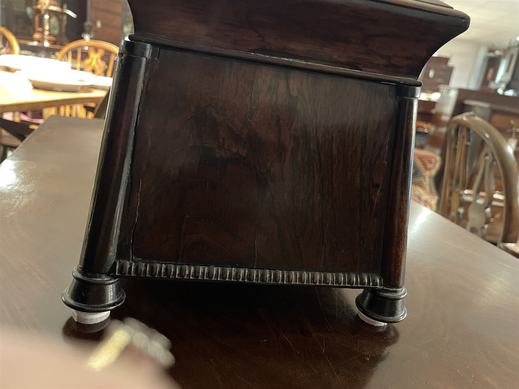 Early 19th century rosewood and brass inlaid tea caddy, of sarcophagus form, the front and hinged opening cover inlaid with brass scrolling panels, opening to reveal a compartmented interior with twin removable boxes with conforming inlaid brass detail to the hinged covers and zinc lining to the interiors, flanking a later glass mixing bowl, the whole upon four turned cylindrical feet, H21cm W36cm D20cm