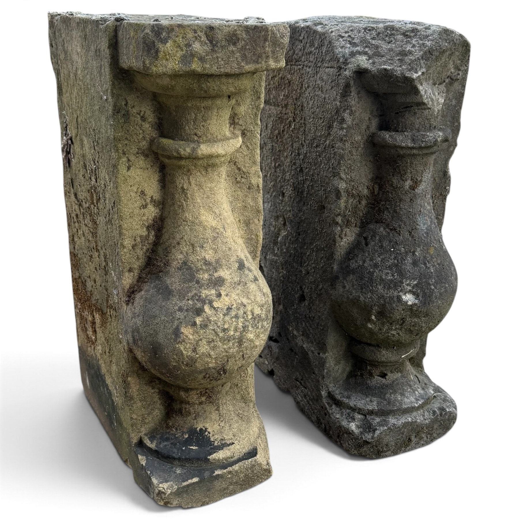 Pair of George III weathered carved sandstone architectural corbels, each with a projecting moulded capital above a half-canted baluster, waisted socle and stepped base