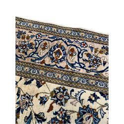 Persian Kashan ivory ground rug, the field decorated with stylised plant motifs and interlacing leafy branches, scrolling border decorated with further plant motifs, floral design guard bands  