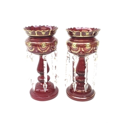  Pair of Victorian ruby glass lustre vases, each with hollow baluster stem, domed base, gilt and enamel decoration, hung with prism drops and lozenges H34cm  