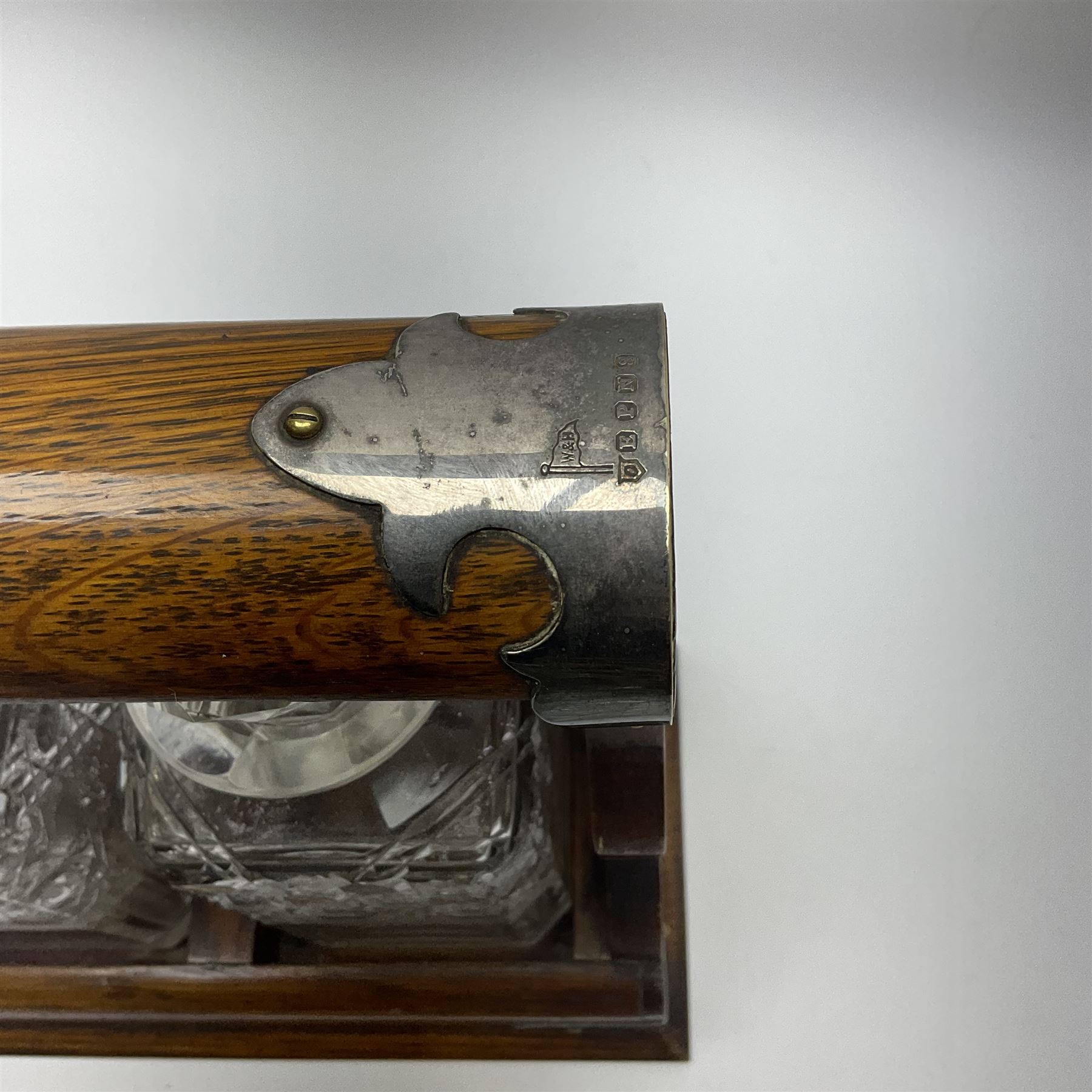 A Mappin & Webb silver plate mounted oak tantalus, containing three square sided cut glass decanters, complete with key, H35cm, together with a further square sided decanter. 