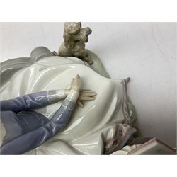 Lladro figure, Poetry of Love, modelled as a boy seated reading from a book next to a girl on garden bench with a dog at her feet, sculpted by Regino Torrijos, with original box, no 5442, year issued 1987, year retired 1998, H22cm