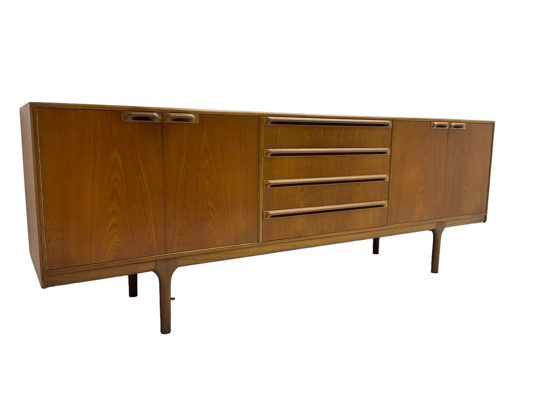 Tom Robertson for AH McIntosh & Co of Kirkaldy - mid-20th century teak sideboard, fitted with four central drawers, flanked by cupboard enclosing shelves and sliding tray, raised on cylindrical supports