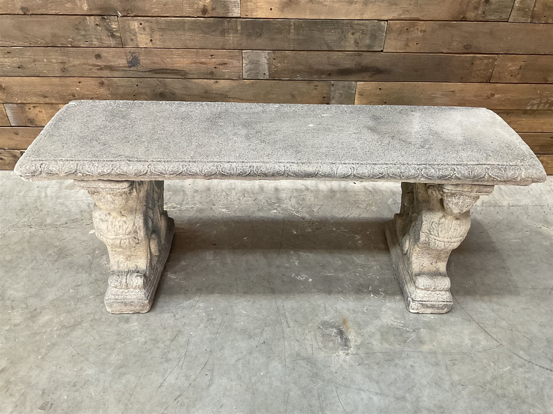 Cast stone garden Rams Head bench, two pillars set with architectural rams heads, rectangular slab seat