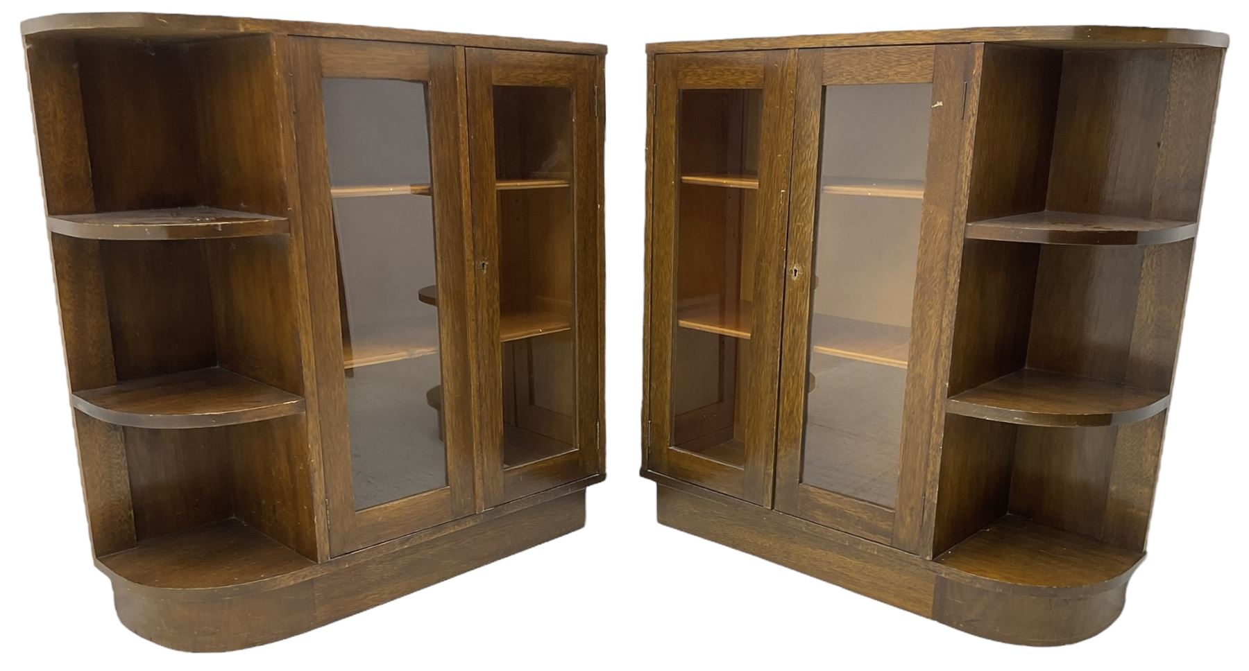 Pair of mid-20th century oak bookcases, rectangular form with curved ends, enclosed by glazed doors and fitted with shelves
