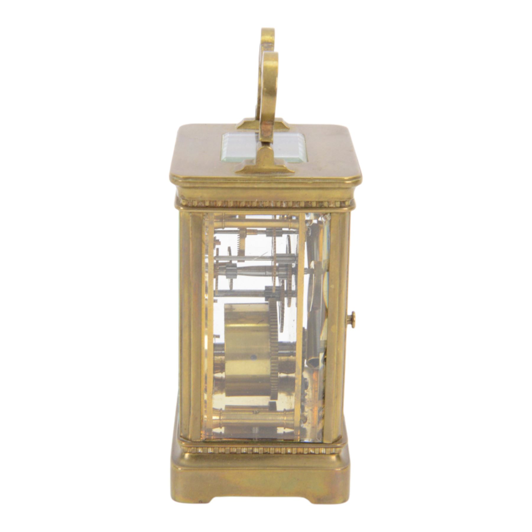 French-Edwardian 8-day timepiece carriage clock with a cylinder platform escapement, anglaise style brass case with four glass panels, dial with a polished gilt mask and foliate decoration, white enamel chapter with Arabic numerals and steel spade hands, . With Key. 