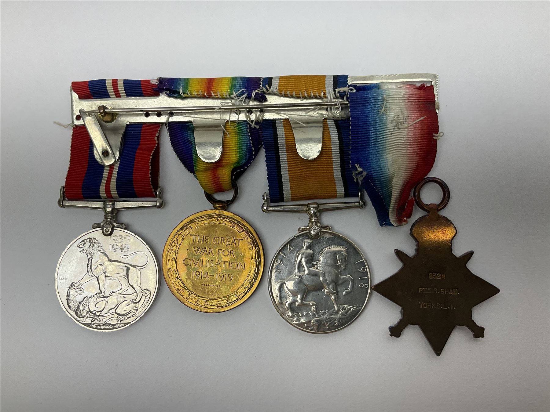 WW1 group of three medals comprising British War Medal, Victory Medal and 1914 Star awarded to 8328 Pte. G. Shaw Yorks: L.I.; on hanging bar with WW2 1939-1945 War Medal and WW1 ribbon bar with rosette to 1914 Star ; all with ribbons; and WW2 1939-1945 War Medal with ribbon