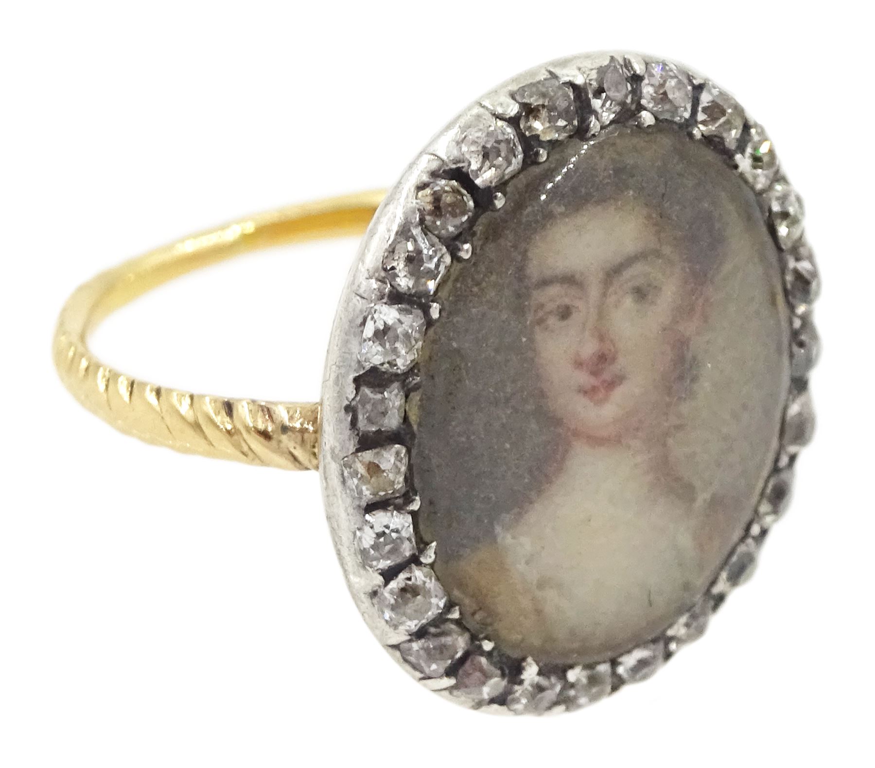 18th/ 19th century gold diamond portrait ring, set with an oval miniature of a woman on ivory, under a glazed panel, with old cut diamond surround and rope twist shank. This lot has been registered for sale under Section 10 of the APHA Ivory Act