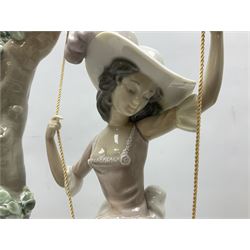 Lladro figure, Swinging, modelled as a woman sat on a swing attached to a tree branch, sculpted by Salvador Debon, no 1297, year issued 1974, year retired 1989, together with Collectors Society items and limited edition eggs, etc, largest example H41cm 