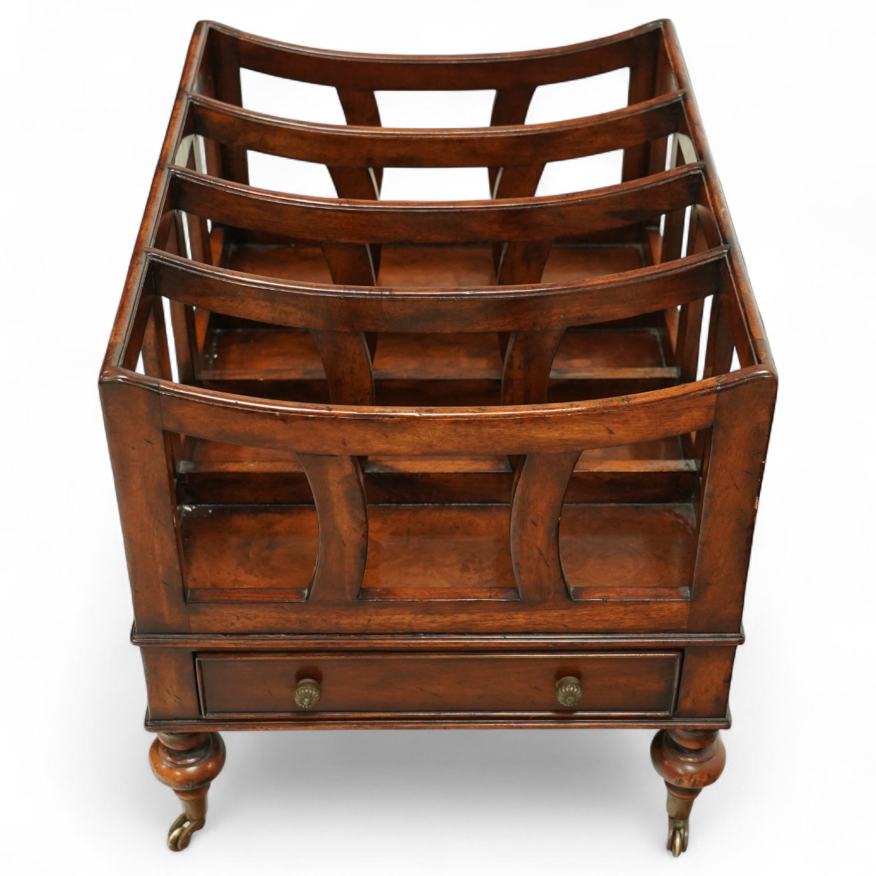 Late 20th century large mahogany canterbury, of rectangular form with four divided curved upper racks, single frieze drawer with brass knob handles, raised on turned legs with brass castors