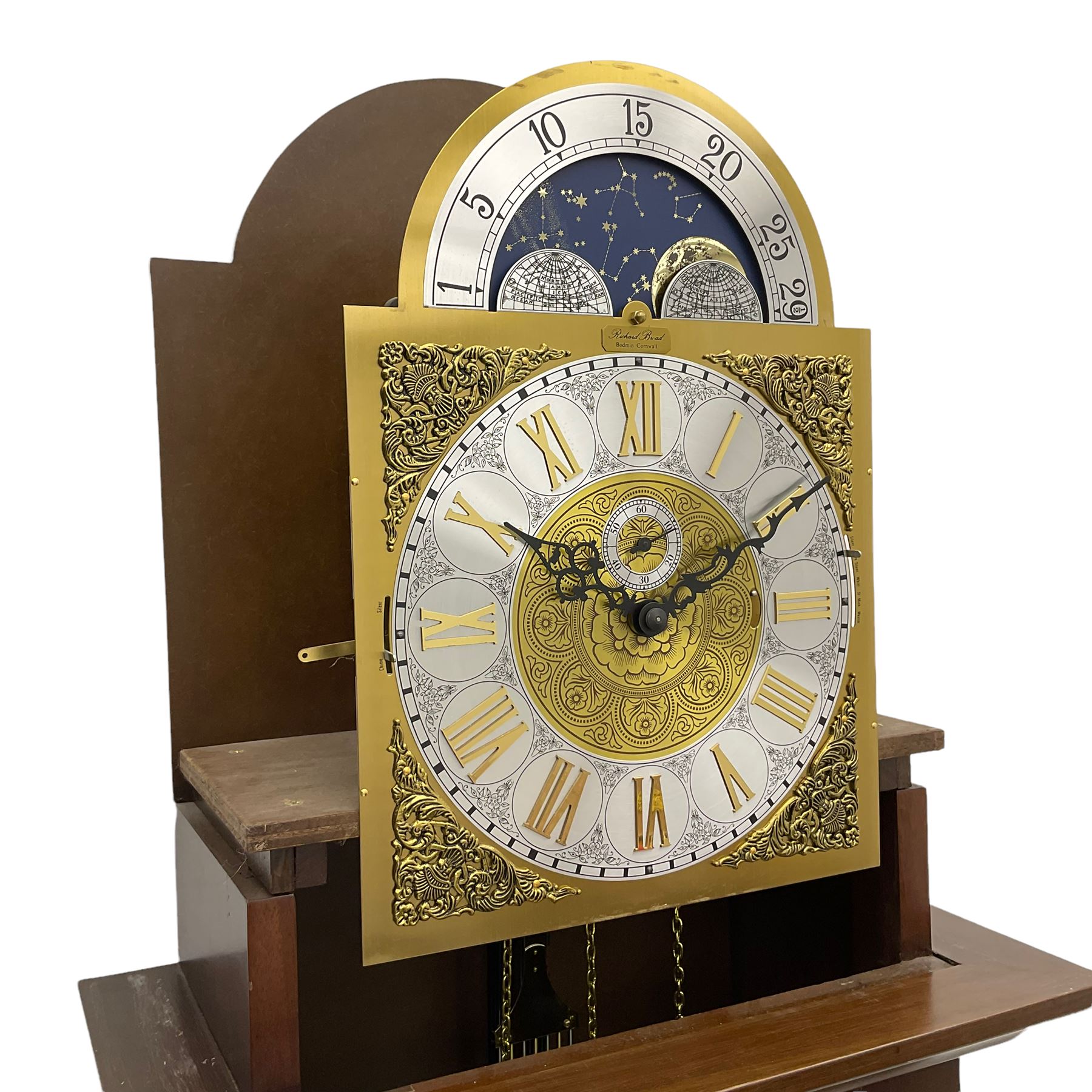 A  20th century longcase clock made to celebrate the millennium in the year 2000, this clock being No 2 of only 200 manufactured by  Richard Broad in Bodmin Cornwall, with a mahogany effect case and traditional swans neck pediment with three brass finials, break arch hood door on a trunk with recessed columns and full length glazed door, on a square plinth with inlay and a shaped base, brass dial with brass spandrels, silvered chapter ring, seconds dial and working moon phase to the arch, weight driven three train movement striking the quarters and hours on 12 gong rods, with a choice of St Michael, Westminster and Wittington chimes, with chime selector and chime/silent facility. With three brass cased weights and gridiron pendulum.





