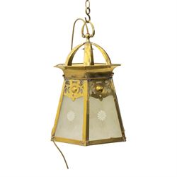 Arts & Crafts brass hall lantern, circa 1900, of hexagonal tapering form with open dome top support and pierced foliate detail above frosted glass panels with flower head detail, H41.5cm D29cm
