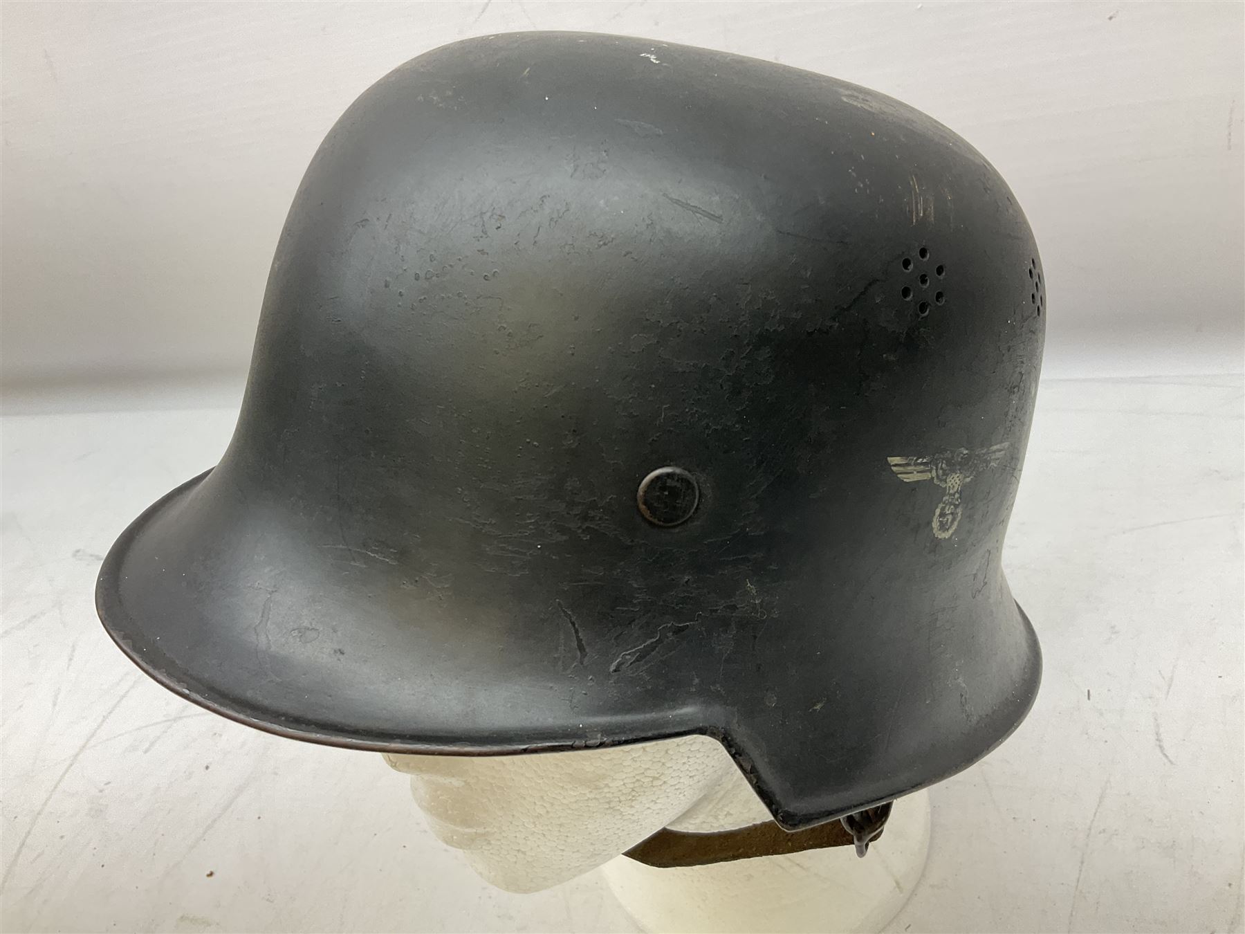 WW2 German steel combat helmet with eagle insignia to one side and U-724 to the other, leather liner marked No.56 and leather chin strap; indistinctly stamped to the skirt '*ahl'