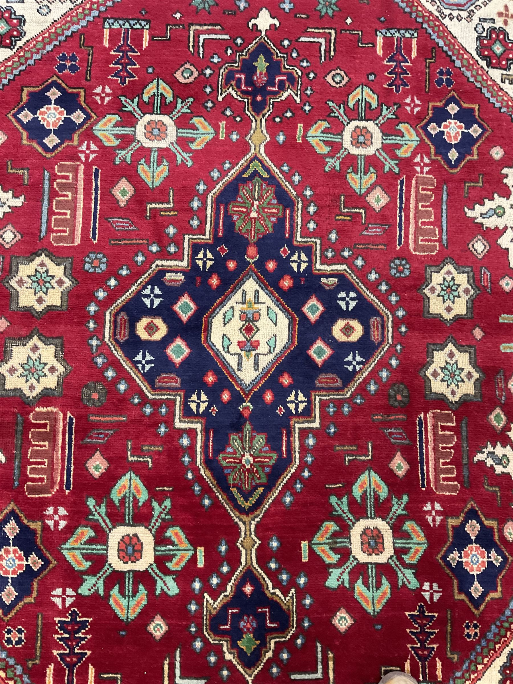 Qashqai red and blue ground rug, with central medallion, green repeating border with geometric motifs 