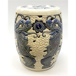 An Oriental style garden seat, or barrel form, pierced and decorated with dragons amongst auspicious clouds, H39.5cm.