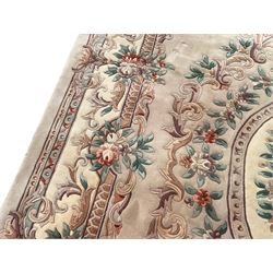 Chinese ivory ground carpet, the central oval medallion surrounding a bouquet, the field decorated with scrolling floral decoration, guarded border with rinceaux, garlands and foliate motifs
