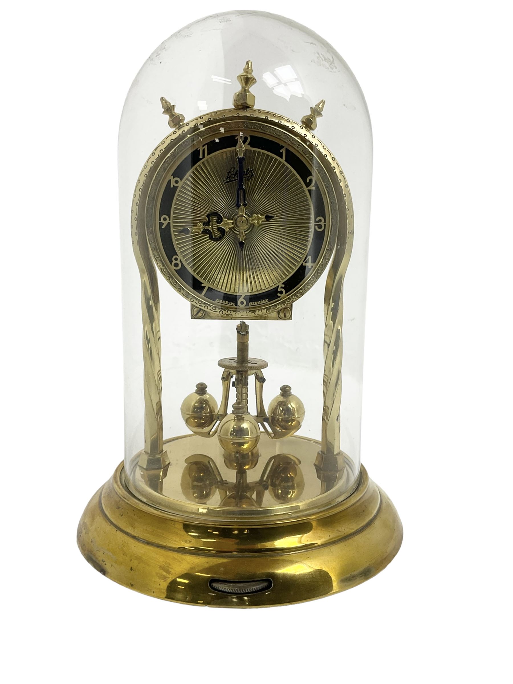 Schatz - mid-20th century German 400 day torsion clock, with a gilt dial and black chapter, Arabic numerals and pierced hands, three ball rotary pendulum and glass dome, original box, packaging and instruction booklet. Torsion suspension spring intact.

