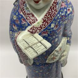 Chinese Republic Period porcelain figure, modelled as scholar holding a book and fan, wearing blue enamelled robes decorated with flower heads, H43cm