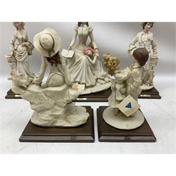 Five Napoli Belcari figures upon wooden plinths, to include a woman with a girl resting on her lap, a girl feeding doves, a girl and boy etc  