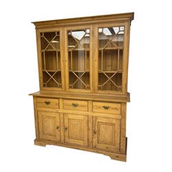 20th century pine glazed bookcase on cupboard, projecting cornice over three astragal glazed doors, the base fitted with three drawers and three panelled cupboards, on bracket feet