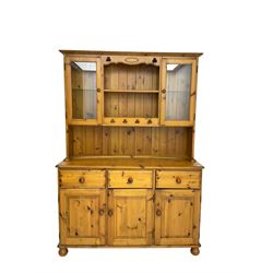Traditional pine kitchen dresser, two-tier plate rack flanked by two glazed cupboards, base fitted with three drawers over three cupboard doors, on bun feet