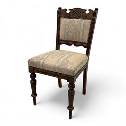 Victorian walnut set of four dining chairs, the shaped and carved top rails with central flowerhead and scroll decoration above upholstered backs and seats in floral woven fabric, brass stud trim, on ring turned front supports