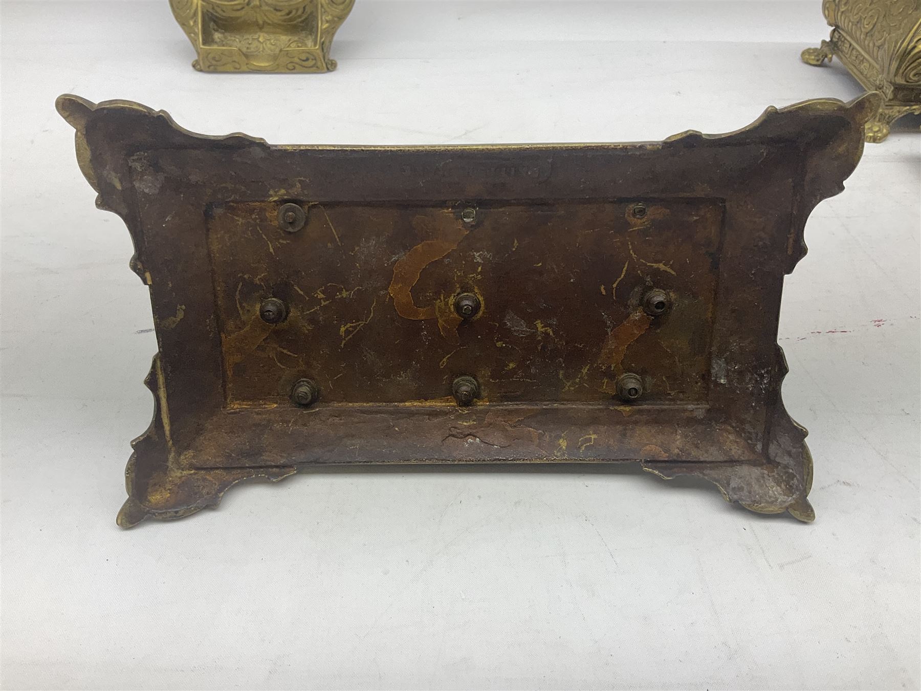 Collection of victorian and later brass desk accessories, to include a letter holder with cherub design, ink well of square form with hinged lid, brass table bell, brass casket with relief decoration, etc  