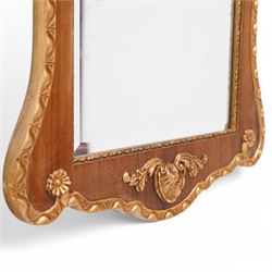 20th-century ornate gilt and mahogany Chippendale style wall mirror, the wooden gilt-edged frame with applied scrollwork with foliate motifs, drape, and tassel decoration 